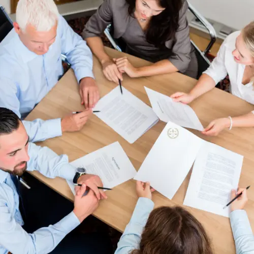 People discussing legal documents together at a meeting table