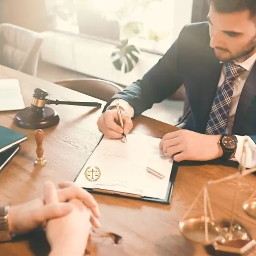 Attorney preparing and signing legal documents during a consultation